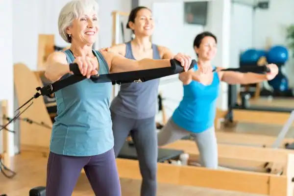 Toning Arms After 60: Empowering Womens Fitness Through Effective Weight Training 2 older woman doing weight training Bakewell and resistance in the gym to tone upper arms