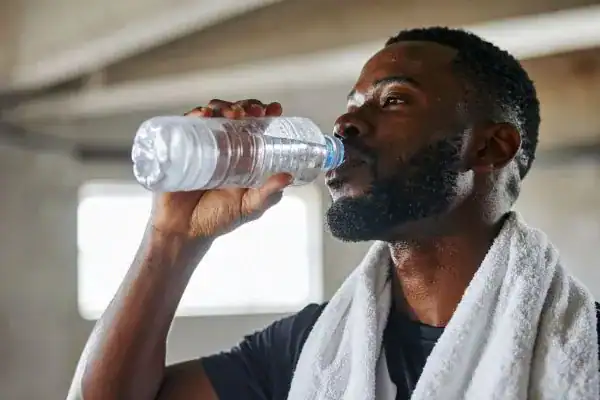 Hydration: The Secret Ingredient for a Toned Stomach and Enhanced Fitness 1 Image of man drinking water to improve hydration Bakewell after work out.